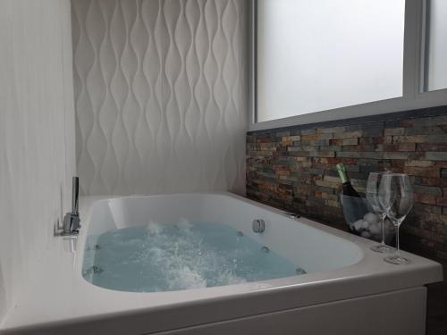 a bath tub with a glass of wine in it at SOHO B&B in Fisciano