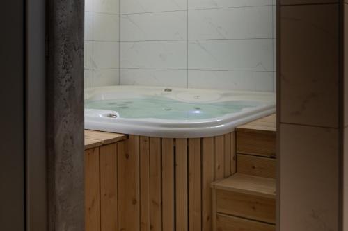 eine große Badewanne in einem Holzbadezimmer in der Unterkunft Flora Lux and Spa Zlatibor in Zlatibor