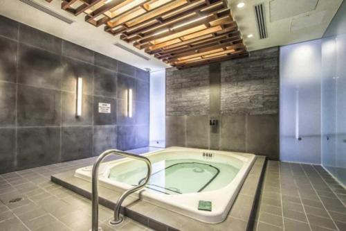 a bathroom with a jacuzzi tub in a room at Stunning 1BR and Den Sleeps 6 Steps From CN Tower in Toronto