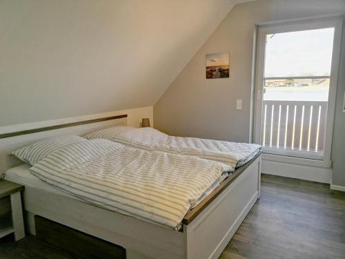 Ce lit se trouve dans un dortoir doté d'une grande fenêtre. dans l'établissement Seehaus Kalle - a90192, à Walchum