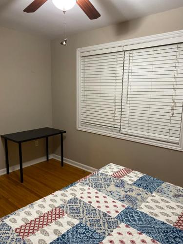 1 dormitorio con cama y mesa junto a una ventana en Comfy Room Stay - Unit 1, en Kingston