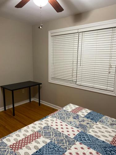 a bedroom with a bed and a table next to a window at Comfy Rooms Stay - Unit 1 in Kingston