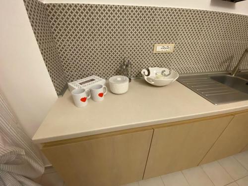 a kitchen counter with three cups and a sink at Nonna Lenuccia in Noci