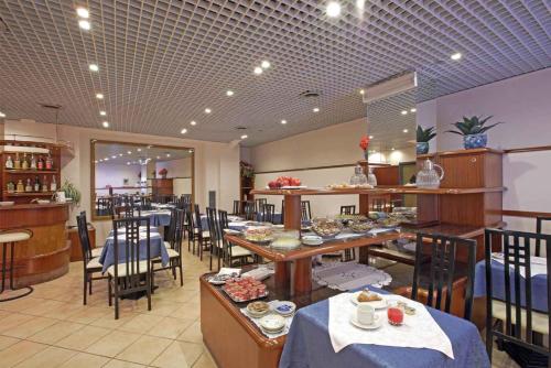 un ristorante con tavoli e sedie con cibo sopra di Hotel Iris a Genova