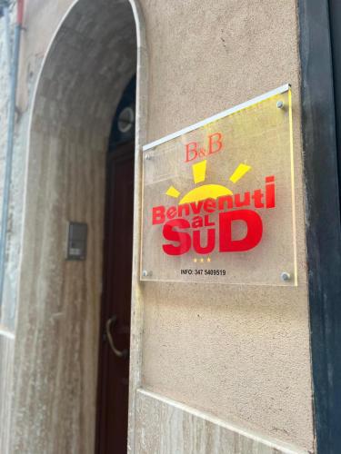 un cartel en el lado de un edificio con un sándwich de bb. en Benvenuti al Sud B&B, en Licata