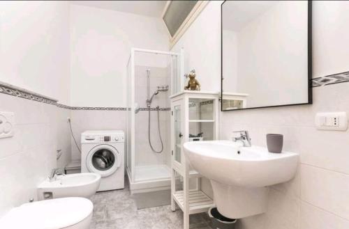 a white bathroom with a sink and a washing machine at Pieve Ligure a picco sul mare con piscina Villa Regina in Pieve Ligure