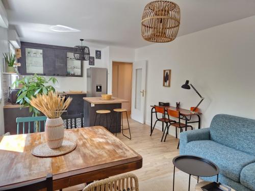 un salon avec un canapé bleu et une table dans l'établissement Appartement Spacieux avec Parking proche MER, à Saint-Nazaire