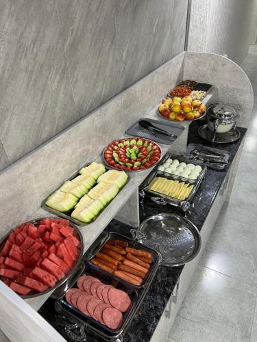 un buffet de diferentes tipos de comida en un mostrador en ReveL HoteL en Tashkent