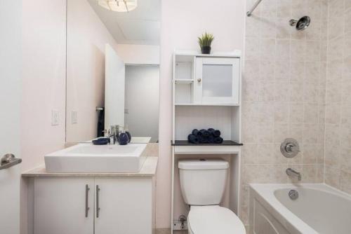 a bathroom with a toilet and a sink and a tub at Urban Lifestyle 1BR Suite w CN Tower and Lake view in Toronto