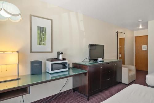 a hotel room with a desk with a microwave and a tv at Wedge Mountain Inn in Leavenworth