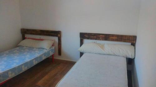 um pequeno quarto com duas camas e um colchão em Casa de campo Espinosa em La Garnatilla