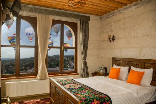 a bedroom with a bed and a window with hot air balloons at My Story Cave Hotel in Uchisar