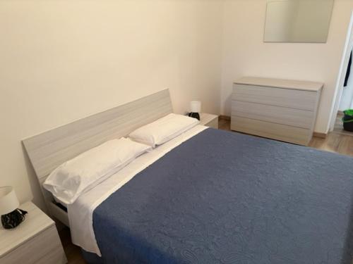 a bedroom with a large bed with a blue comforter at Appartamenti Monti Como Lake in Brunate