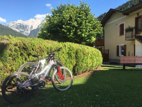 two bikes are parked next to a house at Hotel Juventus in Auronzo di Cadore