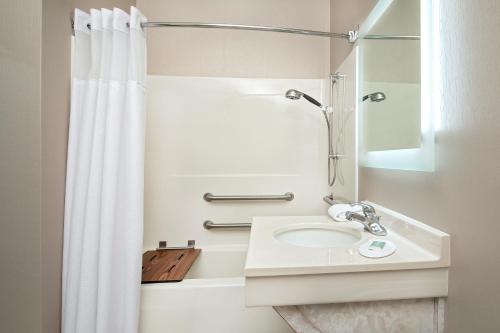 a white bathroom with a sink and a shower at SpringHill Suites by Marriott Hershey Near The Park in Hershey