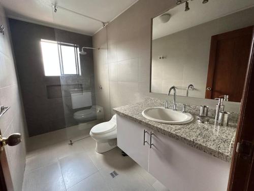 uma casa de banho com um lavatório, um WC e um espelho. em Spacious Apartment in Bellavista - Beautiful City Views em Quito