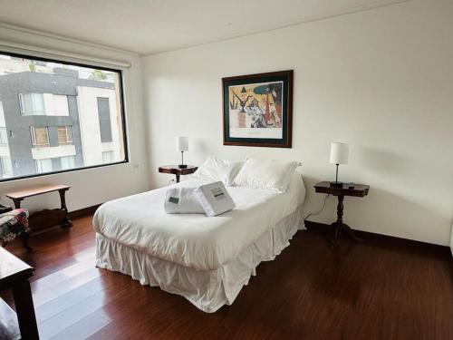 um quarto com uma grande cama branca e uma janela em Spacious Apartment in Bellavista - Beautiful City Views em Quito