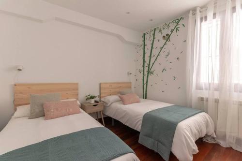 a bedroom with two beds and a window at Plaza Unamuno - Casco Viejo - PARKING opcional in Bilbao