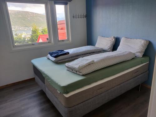 dois colchões sentados numa cama num quarto com uma janela em FeelHome 3 bedroom Near University em Tromsø