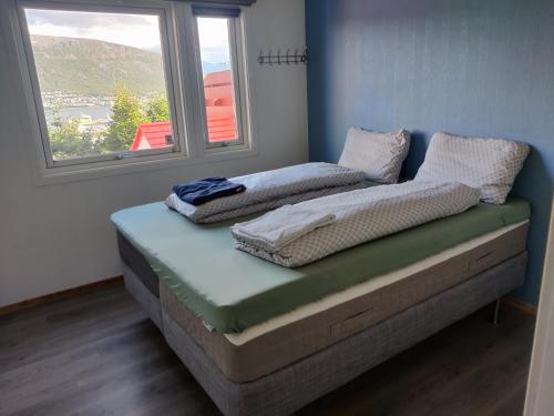 two mattresses sitting on a bed in a room with a window at FeelHome 3 bedroom Near University in Tromsø