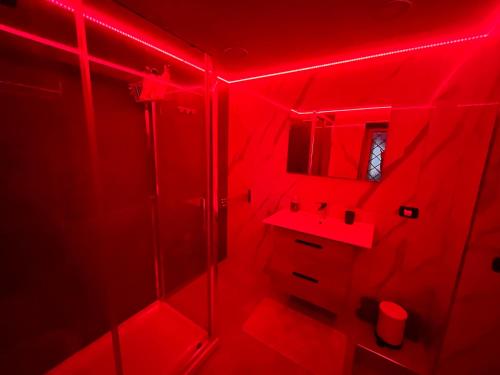 a red bathroom with a sink and a mirror at casa esmeralda in Naples