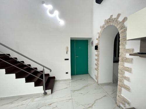 a hallway with a green door and stairs at casa esmeralda in Naples