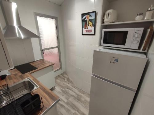 a small kitchen with a refrigerator and a microwave at Centre Sweet Home in Málaga
