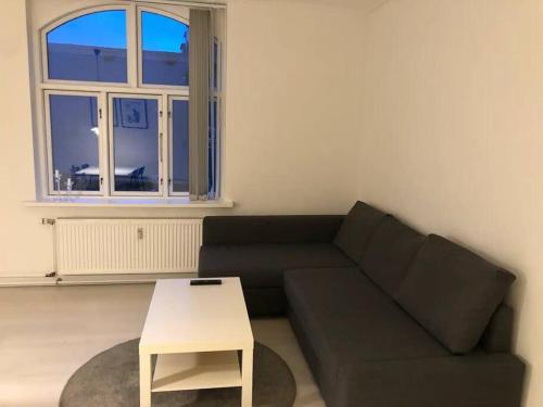 sala de estar con sofá y mesa en Apartment Wilma en Aalborg