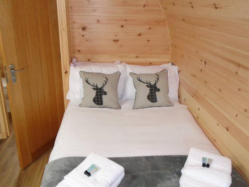 Cama en habitación con pared de madera en Croisgeir Self Catering Pod, en Daliburgh