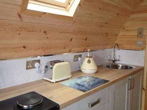 a kitchen with a counter with a toaster and a sink at Croisgeir Self Catering Pod in Daliburgh