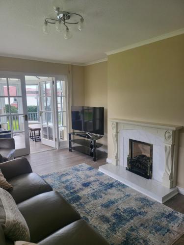 a living room with a fireplace and a tv at Royal Court Hotel in Portrush