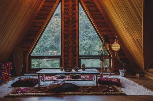 Habitación con mesa frente a una ventana grande. en Sabay Sai Wooden Guesthouse in The National Park, en Almaty