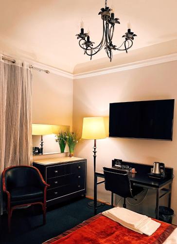 a hotel room with a desk and a television at Excelsior INN in Turda