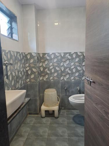 uma casa de banho com um WC, uma banheira e um lavatório. em Hotel Gitanjali em Ahmedabad