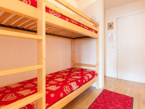 - une chambre avec 2 lits superposés et des draps rouges dans l'établissement Charmant studio pour 4 avec balcon exposé sud en plein centre d'Avoriaz - FR-1-314-184, à Morzine