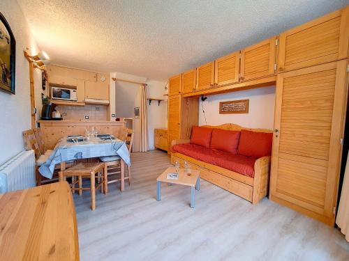 un salon avec un canapé rouge et une table dans l'établissement Studio duplex agréable Au pied des pistes Balcon - FR-1-344-921, aux Menuires