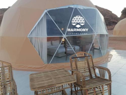 a tent with chairs and a table in front of it at Harmony Luxury Camp in Wadi Rum