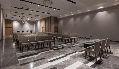 a conference room with tables and chairs and a wall at Hotel Giralda Center in Seville