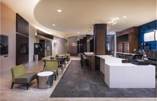 a lobby with a bar and tables and chairs at Courtyard by Marriott Greenville Downtown in Greenville