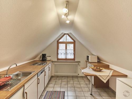 an attic kitchen with a sink and a window at Landgasthof Adler Pelzmühle in Biederbach Baden-Württemberg