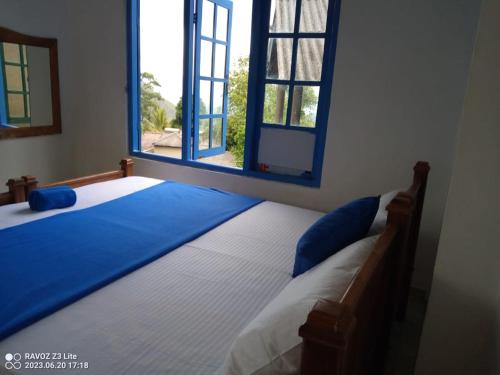 a bedroom with a bed with a large window at Green View Ella in Ella