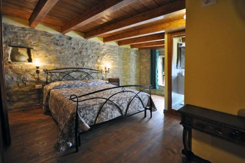 a bedroom with a bed and a stone wall at La Corte del Monte 