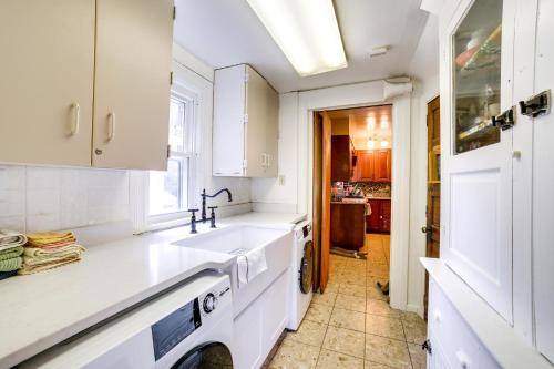 una cocina con armarios blancos y fregadero en Spacious Pittsburgh Rental Walk to Frick Park! en Pittsburgh