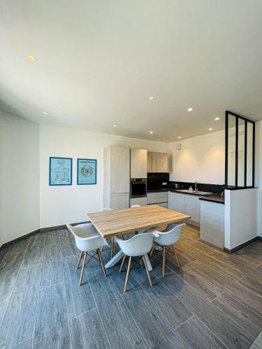 une cuisine et une salle à manger avec une table et des chaises en bois dans l'établissement cote sud deux chambres proche croisette, à Cannes