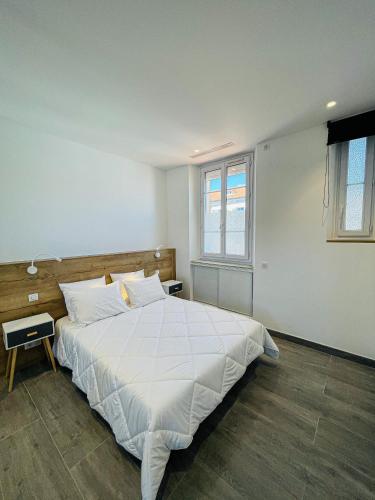 une chambre avec un grand lit avec des draps blancs dans l'établissement cote sud deux chambres proche croisette, à Cannes