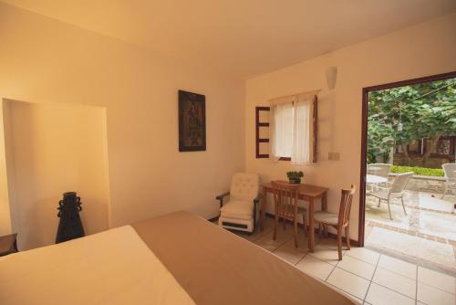 een slaapkamer met een bed en een tafel en stoelen bij Las Mariposas Hotel & Studios in Oaxaca City