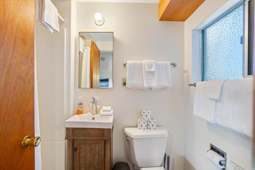 een badkamer met een toilet, een wastafel en een spiegel bij Marrowstone Island Beach Cabin in Nordland
