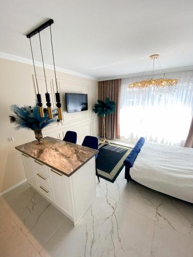 um quarto com uma cama grande e um lustre em Glamor Lux em Gdańsk