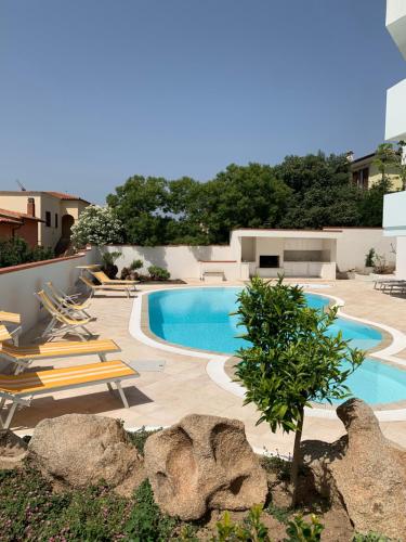 una piscina con sedie a sdraio accanto a un edificio di Villa Ada Olbia a Olbia