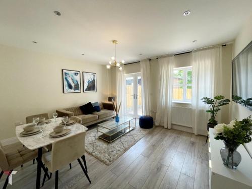 a living room with a table and a couch at Newbuild, 3 Bedroom house with free parking in Aldershot